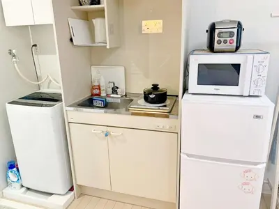 a small kitchen with a microwave on top of a refrigerator at JR t akadababa subway 5 mins walk! Newly building \u65b0\u7bc9! \u9ad8\u7530\u99ac\u5834\u99c5 \u5f92\u6b69\u570f\u5185\u5927\u4eba\u6c17! Shinjuku\u65b0\u5bbf\u5708!\u9ad8\u901f\u65e0\u9650\u5236Wi-FI C1 in Tokyo