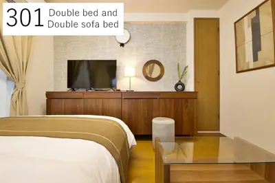 a bedroom with a bed and a table and a tv at \u5927\u4e95\u753a\u30a2\u30d1\u30fc\u30c8\u30e1\u30f3\u30c8\u30db\u30c6\u30eb\u8c4a\u5f37\u30d3\u30eb in Tokyo