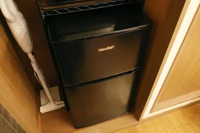 a black refrigerator in a kitchen next to a wall at \u5927\u4e95\u753a\u30a2\u30d1\u30fc\u30c8\u30e1\u30f3\u30c8\u30db\u30c6\u30eb\u8c4a\u5f37\u30d3\u30eb in Tokyo