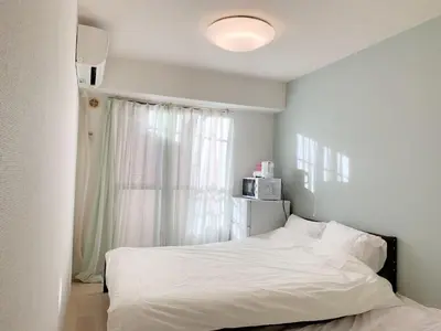 a bedroom with a white bed and a window at Shinjuku Center\u65b0\u5bbf\u4e2d\u5fc3! !Shinjuku Kabukicho! 3min walk! JR \u65b0\u5bbf!\u5730\u94c1\u7ad9\u6b65\u884c3\u5206! \u65b0\u5bbf\u6b4c\u821e\u4f0e!\u8457\u540d\u8fde\u9501\u5927\u578b\u516c\u5bd3!\u4e00\u5c4224\u5c0f\u65f6\u4fdd\u5b89\u5e38\u9a7b! 616 in Tokyo