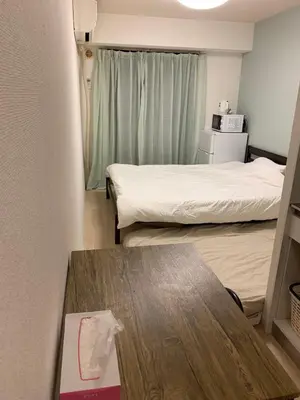a small room with two beds and a table at Shinjuku Center\u65b0\u5bbf\u4e2d\u5fc3! !Shinjuku Kabukicho! 3min walk! JR \u65b0\u5bbf!\u5730\u94c1\u7ad9\u6b65\u884c3\u5206! \u65b0\u5bbf\u6b4c\u821e\u4f0e!\u8457\u540d\u8fde\u9501\u5927\u578b\u516c\u5bd3!\u4e00\u5c4224\u5c0f\u65f6\u4fdd\u5b89\u5e38\u9a7b! 616 in Tokyo