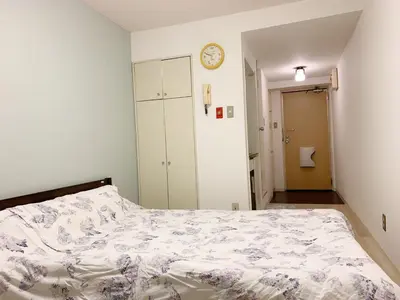 a bedroom with a bed and a clock on the wall at Shinjuku Center\u65b0\u5bbf\u4e2d\u5fc3! !Shinjuku Kabukicho! 3min walk! JR \u65b0\u5bbf!\u5730\u94c1\u7ad9\u6b65\u884c3\u5206! \u65b0\u5bbf\u6b4c\u821e\u4f0e!\u8457\u540d\u8fde\u9501\u5927\u578b\u516c\u5bd3!\u4e00\u5c4224\u5c0f\u65f6\u4fdd\u5b89\u5e38\u9a7b! 616 in Tokyo