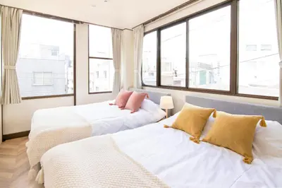 two beds in a room with large windows at Meee Asakusa3F4F \u6d45\u8349\u5f92\u6b693\u5206 140\u5e73\u7c73Max22\u540d \u7121\u6599\u99d0\u8eca\u5834 \u5c4b\u4e0a\u7d76\u666f \u6e0b\u8c37\u76f4\u901a in Tokyo