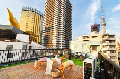 a balcony with a table and chairs and some buildings at Meee Asakusa3F4F \u6d45\u8349\u5f92\u6b693\u5206 140\u5e73\u7c73Max22\u540d \u7121\u6599\u99d0\u8eca\u5834 \u5c4b\u4e0a\u7d76\u666f \u6e0b\u8c37\u76f4\u901a in Tokyo