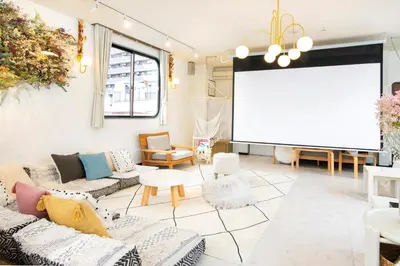 a living room with couches and a projection screen at Meee Asakusa3F4F \u6d45\u8349\u5f92\u6b693\u5206 140\u5e73\u7c73Max22\u540d \u7121\u6599\u99d0\u8eca\u5834 \u5c4b\u4e0a\u7d76\u666f \u6e0b\u8c37\u76f4\u901a in Tokyo