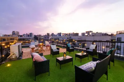 a rooftop patio with chairs and tables on a roof at Meee Asakusa3F4F \u6d45\u8349\u5f92\u6b693\u5206 140\u5e73\u7c73Max22\u540d \u7121\u6599\u99d0\u8eca\u5834 \u5c4b\u4e0a\u7d76\u666f \u6e0b\u8c37\u76f4\u901a in Tokyo