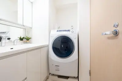 a washing machine in a bathroom next to a sink at ANGO Shibuya I in Tokyo