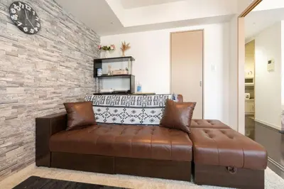 a couch in a living room with a brick wall at ANGO Shibuya I in Tokyo