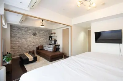 a bedroom with a bed and a living room at ANGO Shibuya I in Tokyo