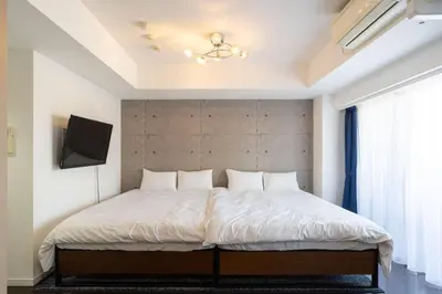 a bedroom with a large white bed in a room at ANGO Shibuya I in Tokyo