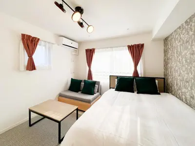 a bedroom with a large white bed and a couch at \u30a6\u30a7\u30eb\u30b9\u30af\u30a8\u30a2\u30a4\u30ba\u30e0\u65b9\u5357\u753a in Tokyo