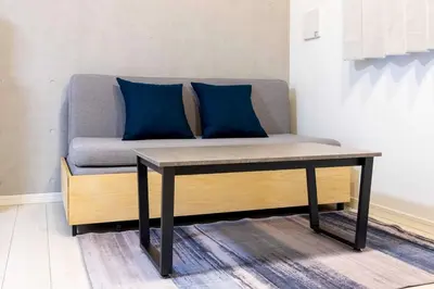 a couch with blue pillows on top of a table at \u30a6\u30a7\u30eb\u30b9\u30af\u30a8\u30a2\u30a4\u30ba\u30e0\u65b9\u5357\u753a in Tokyo