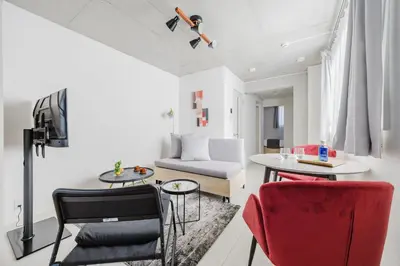 a living room with a couch and a table and chairs at \u30a6\u30a7\u30eb\u30b9\u30af\u30a8\u30a2\u30a4\u30ba\u30e0\u65b9\u5357\u753a in Tokyo