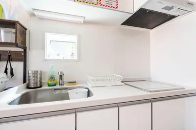 a kitchen with white cabinets and a sink at \u30a2\u30f3\u30c9\u30b9\u30c6\u30a4\u4e0a\u9ad8\u75302\u4e01\u76ee in Tokyo