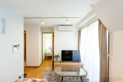a living room with a table and a television at Elle's Shirokane Guest house 301 in Tokyo