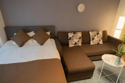 a living room with a bed and a couch at New Design Apartment in Shinjuku Kabukicho! 3 mins station in Tokyo