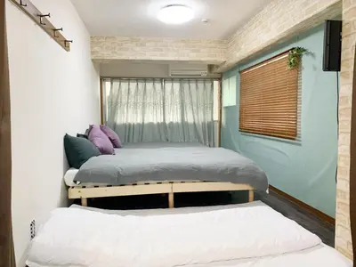 a bedroom with two beds and a window at Ueno\u4e0a\u91ce!Akihabara\u79cb\u8449\u539f!Asakusa \u6d45\u8349!3min walk to station!\u4ea4\u901a\u4fbf\u5229\u5730\u70b9\u7e41\u534e!\u9644\u8fd1\u7f8e\u98df!\u5546\u573a\u767e\u8d27\u904d\u5730! \u5e72\u6e7f\u5206\u79bb! \u667a\u80fd\u9a6c\u6876! \u9ad8\u901f\u65e0\u9650\u5236\u7f51\u8def! \u9ad8\u7ea7\u516c\u5bd3403 in Tokyo