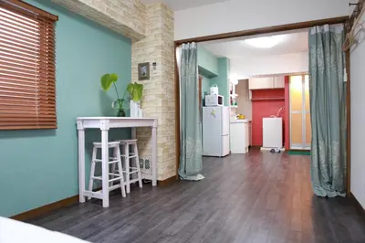 a living room with a table and a refrigerator at Ueno\u4e0a\u91ce!Akihabara\u79cb\u8449\u539f!Asakusa \u6d45\u8349!3min walk to station!\u4ea4\u901a\u4fbf\u5229\u5730\u70b9\u7e41\u534e!\u9644\u8fd1\u7f8e\u98df!\u5546\u573a\u767e\u8d27\u904d\u5730! \u5e72\u6e7f\u5206\u79bb! \u667a\u80fd\u9a6c\u6876! \u9ad8\u901f\u65e0\u9650\u5236\u7f51\u8def! \u9ad8\u7ea7\u516c\u5bd3403 in Tokyo