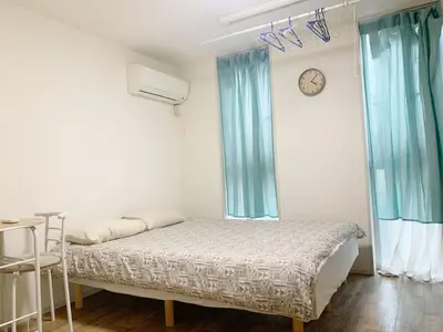 a bedroom with a bed and a clock on the wall at Shinjuku \u65b0\u5bbf\u5f92\u6b65\u5708!\u897f\u65b0\u5bbf!\u90fd\u5385!\u65b0\u5bbf\u4e2d\u592e\u516c\u56ed!2\u5206\u949f\u6b65\u884c\u5230\u5730\u94c1!\u9ad8\u901f\u65e0\u9650\u5236\u7f51\u7edc!\u7cbe\u81f4\u516c\u5bd3Autolock!104 in Tokyo