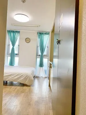 a bedroom with a bed and a window with blue curtains at Shinjuku \u65b0\u5bbf\u5f92\u6b65\u5708!\u897f\u65b0\u5bbf!\u90fd\u5385!\u65b0\u5bbf\u4e2d\u592e\u516c\u56ed!2\u5206\u949f\u6b65\u884c\u5230\u5730\u94c1!\u9ad8\u901f\u65e0\u9650\u5236\u7f51\u7edc!\u7cbe\u81f4\u516c\u5bd3Autolock!104 in Tokyo