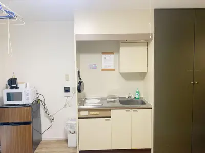 a small kitchen with a sink and a microwave at Shinjuku \u65b0\u5bbf\u5f92\u6b65\u5708!\u897f\u65b0\u5bbf!\u90fd\u5385!\u65b0\u5bbf\u4e2d\u592e\u516c\u56ed!2\u5206\u949f\u6b65\u884c\u5230\u5730\u94c1!\u9ad8\u901f\u65e0\u9650\u5236\u7f51\u7edc!\u7cbe\u81f4\u516c\u5bd3Autolock!104 in Tokyo