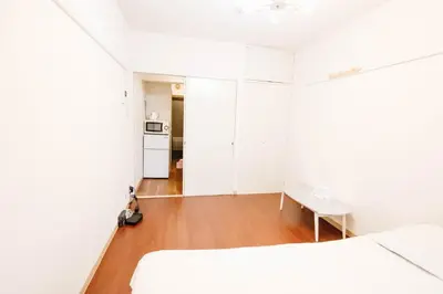 a white bedroom with a bed and a table at Near Shinjuku!Nishi Shinjuku Gochome 6min!\u897f\u65b0\u5bbf!\u5730\u94c1\u7ad9\u6b65\u884c6\u5206!\u65b0\u5bbf\u5f92\u6b65\u5708!\u7cbe\u81f4\u516c\u5bd3! \u9ad8\u901f\u65e0\u9650\u5236WIFI 203 in Tokyo