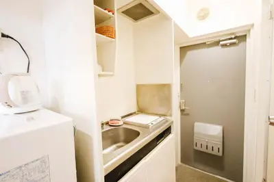 a small kitchen with a sink and a washing machine at Near Shinjuku!Nishi Shinjuku Gochome 6min!\u897f\u65b0\u5bbf!\u5730\u94c1\u7ad9\u6b65\u884c6\u5206!\u65b0\u5bbf\u5f92\u6b65\u5708!\u7cbe\u81f4\u516c\u5bd3! \u9ad8\u901f\u65e0\u9650\u5236WIFI 203 in Tokyo