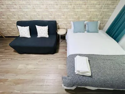 a bedroom with two beds and a couch at Shinjuku-Kabukicho-SJ0012 in Tokyo
