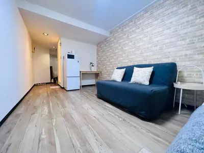 a living room with a blue couch and a brick wall at Shinjuku-Kabukicho-SJ0012 in Tokyo