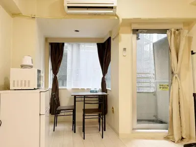 a small kitchen with a table and a refrigerator at Ikebukuro Center# Ikebukuro 5min walk#\u6c60\u888b\u4e2d\u5fc3\u5730\u5e26# \u6c60\u888b\u8f66\u7ad9\u6b65\u884c5\u5206#\u65e0\u9650\u5236wifi #\u6771\u5efa702 in Tokyo