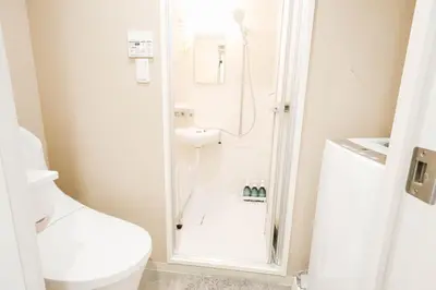 a white bathroom with a shower and a toilet at Ikebukuro Center! Ikebukuro 5min walk! \u6c60\u888b\u4e2d\u5fc3\u5730\u5e26! \u6c60\u888b\u8f66\u7ad9\u6b65\u884c5\u5206! \u516c\u5bd3\u5e72\u6e7f\u5206\u79bb! \u667a\u80fd\u9a6c\u6876! \u9ad8\u901f\u65e0\u9650\u5236\u7f51\u8def!804 in Tokyo