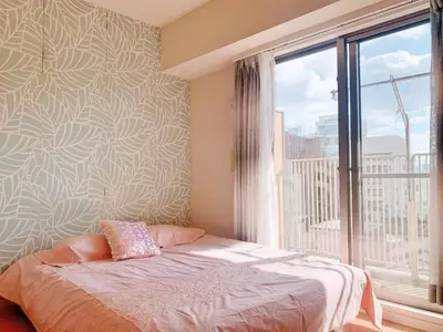 a bedroom with a bed and a large window at Ikebukuro Center! Ikebukuro 6min walk! \u6c60\u888b\u4e2d\u5fc3\u5730\u5e26! \u6c60\u888b\u8f66\u7ad9\u6b65\u884c6\u5206! \u516c\u5bd3\u5e72\u6e7f\u5206\u79bb! \u667a\u80fd\u9a6c\u6876! \u9ad8\u901f\u65e0\u9650\u5236\u7f51\u8def!603 in Tokyo