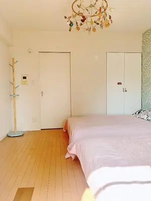 a bedroom with two beds and a chandelier at Ikebukuro Center! Ikebukuro 6min walk! \u6c60\u888b\u4e2d\u5fc3\u5730\u5e26! \u6c60\u888b\u8f66\u7ad9\u6b65\u884c6\u5206! \u516c\u5bd3\u5e72\u6e7f\u5206\u79bb! \u667a\u80fd\u9a6c\u6876! \u9ad8\u901f\u65e0\u9650\u5236\u7f51\u8def!603 in Tokyo