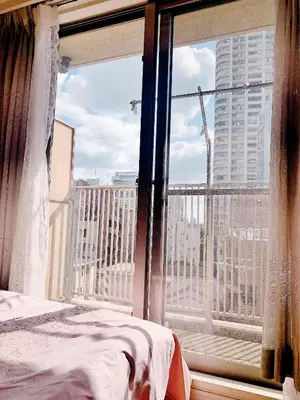 a bedroom with a view of a city from a window at Ikebukuro Center! Ikebukuro 6min walk! \u6c60\u888b\u4e2d\u5fc3\u5730\u5e26! \u6c60\u888b\u8f66\u7ad9\u6b65\u884c6\u5206! \u516c\u5bd3\u5e72\u6e7f\u5206\u79bb! \u667a\u80fd\u9a6c\u6876! \u9ad8\u901f\u65e0\u9650\u5236\u7f51\u8def!603 in Tokyo
