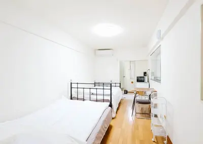 a white bedroom with two beds and a table at Ikebukuro Center# Ikebukuro 9min walk#\u6c60\u888b\u4e2d\u5fc3\u5730\u5e26# \u6c60\u888b\u8f66\u7ad9\u6b65\u884c9\u5206# \u9ad8\u901f\u65e0\u9650\u5236WIFI #\u8bbe\u65bd\u9f50\u5168 \u5b89\u9759\u6574\u6d01201 in Tokyo