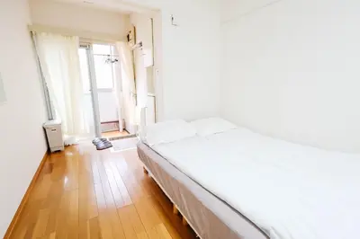 a bedroom with a white bed and a wooden floor at Ikebukuro Center# Ikebukuro 9min walk#\u6c60\u888b\u4e2d\u5fc3\u5730\u5e26# \u6c60\u888b\u8f66\u7ad9\u6b65\u884c9\u5206# \u9ad8\u901f\u65e0\u9650\u5236WIFI #\u8bbe\u65bd\u9f50\u5168 \u5b89\u9759\u6574\u6d01201 in Tokyo