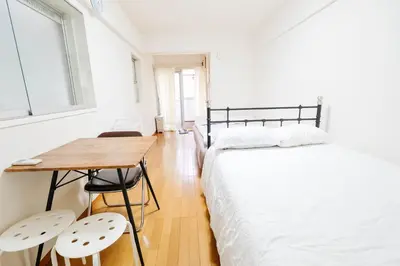 a bedroom with a bed and a table and chairs at Ikebukuro Center# Ikebukuro 9min walk#\u6c60\u888b\u4e2d\u5fc3\u5730\u5e26# \u6c60\u888b\u8f66\u7ad9\u6b65\u884c9\u5206# \u9ad8\u901f\u65e0\u9650\u5236WIFI #\u8bbe\u65bd\u9f50\u5168 \u5b89\u9759\u6574\u6d01201 in Tokyo
