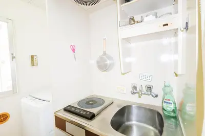 a small kitchen with a sink and a stove at Ikebukuro Center# Ikebukuro 9min walk#\u6c60\u888b\u4e2d\u5fc3\u5730\u5e26# \u6c60\u888b\u8f66\u7ad9\u6b65\u884c9\u5206# \u9ad8\u901f\u65e0\u9650\u5236WIFI #\u8bbe\u65bd\u9f50\u5168 \u5b89\u9759\u6574\u6d01201 in Tokyo