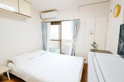 a bedroom with a white bed and a window at Shinjuku Area/Nishi-Shinjuku Gochome subway 6 minutes walk/西新宿五丁目车站步行6分钟 211 in Tokyo