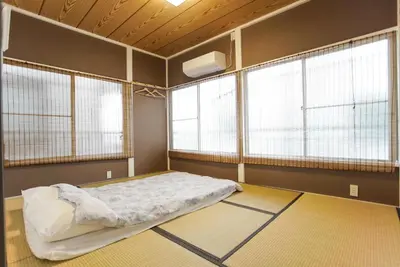 a bedroom with a bed in a room with windows at \u5929\u7a7a\u6811\u8fd1\u5728\u54ab\u5c3a! \u6d45\u8349\u79cb\u53f6\u539f\u5708\u5185! \u6700\u8fd1\u5730\u94c1\u6b65\u884c3\u5206\u949f! Near Skytree Asakusa!station 3 mins walk !\u5e72\u6e7f\u5206\u79bb! \u667a\u80fd\u9a6c\u6876! \u9ad8\u901f\u65e0\u9650\u5236\u7f51\u8def! 3LDK! Skytree in Tokyo