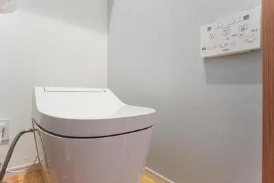 a white toilet in a room with a wall at \u5929\u7a7a\u6811\u8fd1\u5728\u54ab\u5c3a! \u6d45\u8349\u79cb\u53f6\u539f\u5708\u5185! \u6700\u8fd1\u5730\u94c1\u6b65\u884c3\u5206\u949f! Near Skytree Asakusa!station 3 mins walk !\u5e72\u6e7f\u5206\u79bb! \u667a\u80fd\u9a6c\u6876! \u9ad8\u901f\u65e0\u9650\u5236\u7f51\u8def! 3LDK! Skytree in Tokyo