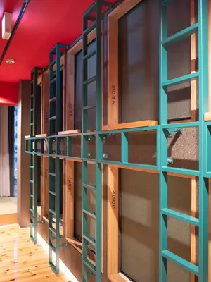 a row of lockers in a room with red ceilings at ELE Cabin Shinjuku Kabukicho in Tokyo