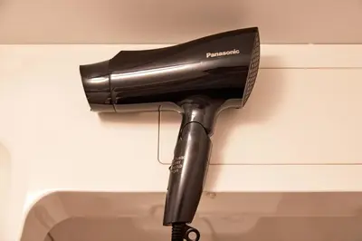 a black blow dryer is hanging on a wall at LiveGRACE Mabuji Park Hotel - Vacation STAY 51980v in Tokyo