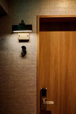 a public restroom with a pay phone and a door at LiveGRACE Mabuji Park Hotel - Vacation STAY 51943v in Tokyo