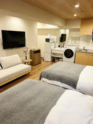 a room with two beds and a kitchen with a sink at Akihabara K in Tokyo