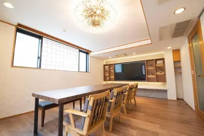 a dining room with a long table and chairs at la3 hotel \u65b0\u5bbf\u4e09\u968e\u5efa\u3066\u4e00\u8ed2\u5bb6\uff08\u5c4b\u5185\u30a8\u30ec\u30d9\u30fc\u30bf\u30fc\u4ed8\u304d) in Tokyo