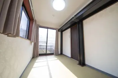 an empty room with large windows in a building at la3 hotel annex \u65b0\u5bbf\u4e09\u968e\u5efa\u3066\u4e00\u8ed2\u5bb6 in Tokyo