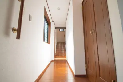 a hallway with a wooden floor and a wooden door at la3 hotel annex \u65b0\u5bbf\u4e09\u968e\u5efa\u3066\u4e00\u8ed2\u5bb6 in Tokyo
