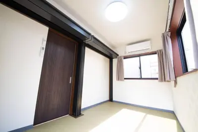an empty room with a door and a window at la3 hotel annex \u65b0\u5bbf\u4e09\u968e\u5efa\u3066\u4e00\u8ed2\u5bb6 in Tokyo