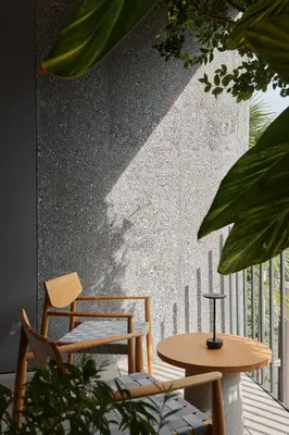 a patio with two chairs and a table and a wall at TRUNK(HOTEL) YOYOGI PARK in Tokyo